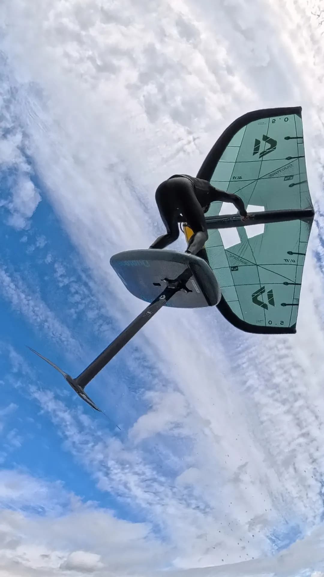 Wingfoiler hebt mit Board und Foil über dem Wasser ab